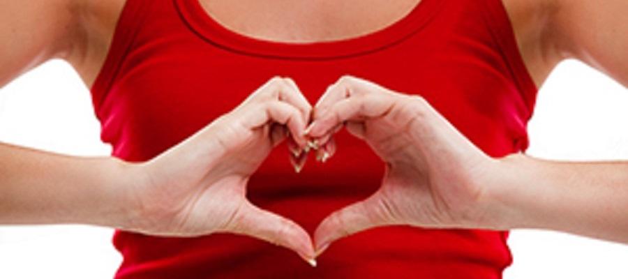 A woman in a red tank top makes a heart with her hands. Her finger form the upper curve of the heart and her thumbs form the bottom point.