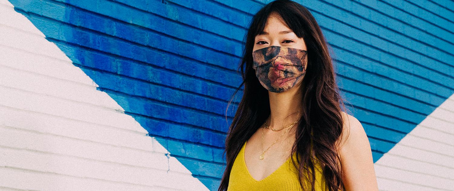 Woman wears yellow blouse and stylish floral mask